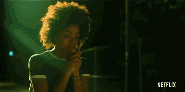 a woman is smoking a cigarette with a netflix logo in the background