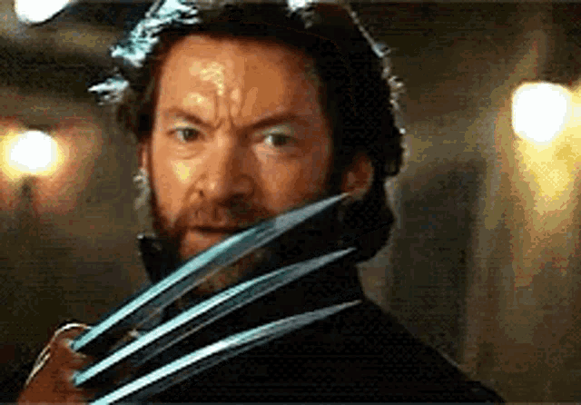a close up of a man with a beard holding a pair of claws in front of his face .