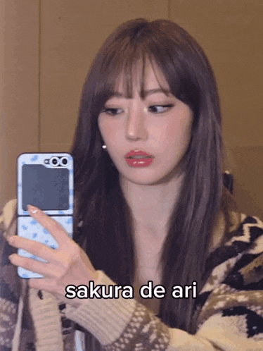 a woman is taking a picture of herself with a cell phone and the caption sakura de ari