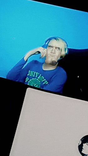 a man wearing headphones and a shirt that says university