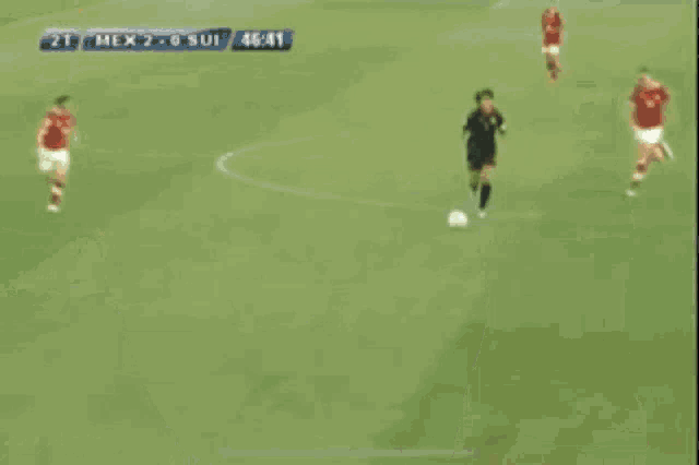 a group of soccer players are hugging each other on a field .