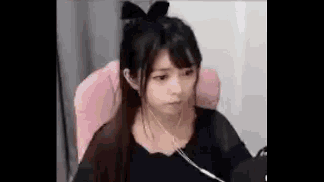 a young girl is sitting in a chair wearing headphones .