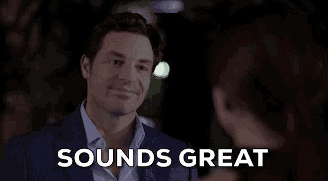 a man in a suit is talking to a woman and the words sounds great are on the screen