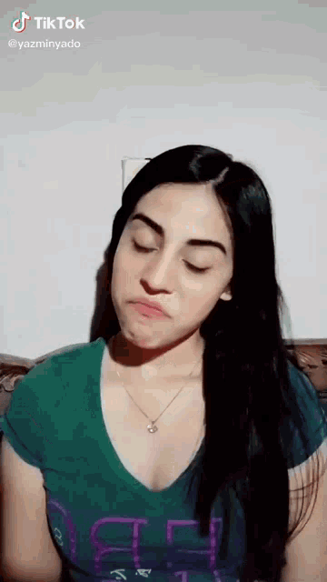 a woman in a green shirt is making a funny face and has a tiktok account