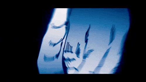 a reflection of a person 's face in a glass of water with a blue background