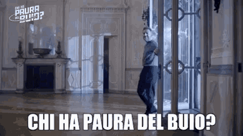 a man is standing in a room with the words chi ha paura del buio
