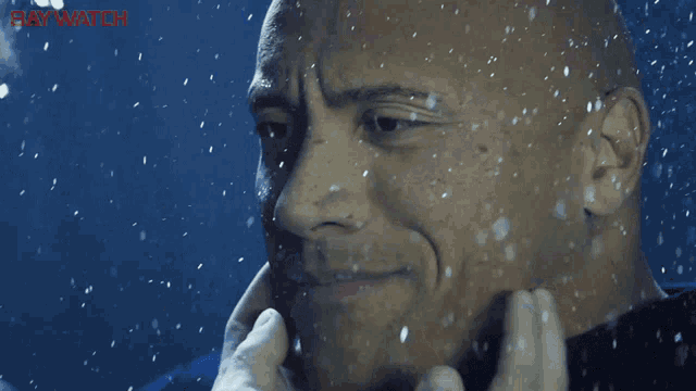 a close up of a man 's face with the word baywatch in the corner