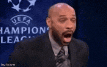 a man in a suit and tie is standing in front of a uefa champions league logo