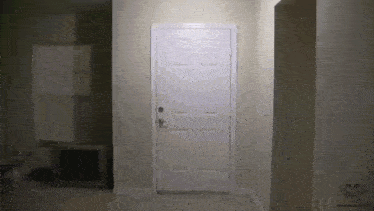 a white door is open in a hallway with a face on the wall