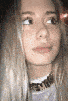 a close up of a woman 's face wearing a choker necklace .