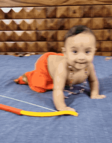 a baby is crawling on a blue bed