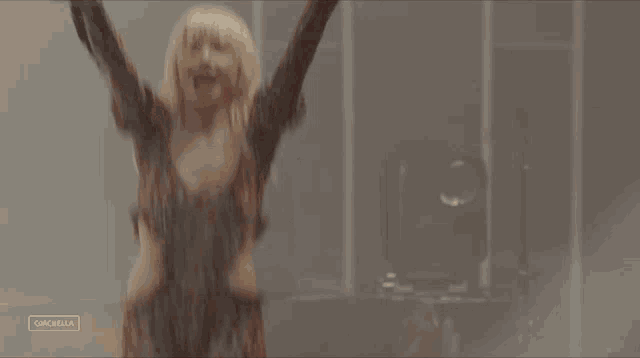 a woman is dancing with her arms in the air and the word coachella is visible in the corner