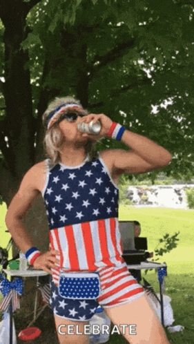 a man wearing an american flag outfit is drinking a beer