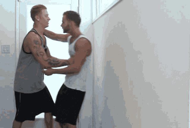 two men are standing next to each other and one of them has a tattoo on his arm that says ' i love you '