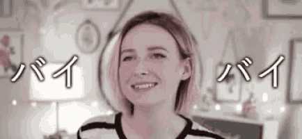 a woman in a striped shirt is smiling in front of a mirror and a lamp .