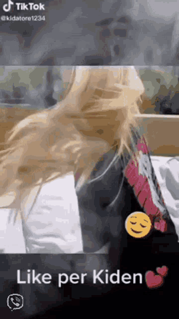 a woman with long blonde hair is sitting on a bed with the words like per kiden on the bottom