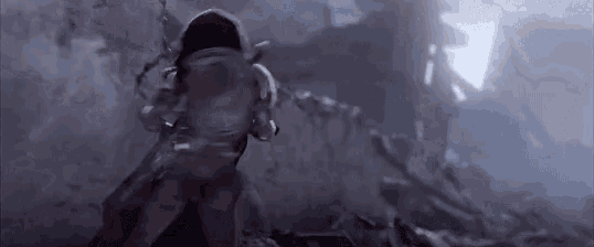 a person is standing on top of a pile of rocks in a dark room .