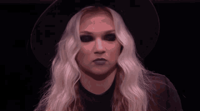 a woman with long blonde hair wearing a black hat
