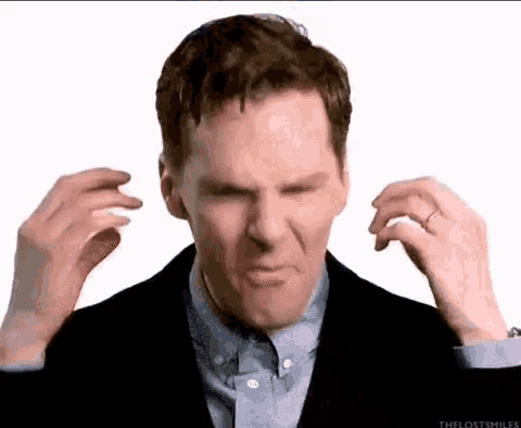 a man in a suit and tie is making a funny face with his hands .
