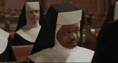 a group of nuns are sitting in a church and one of them is wearing a white hat