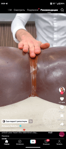 a screenshot of a tiktok video shows a man holding a piece of chocolate