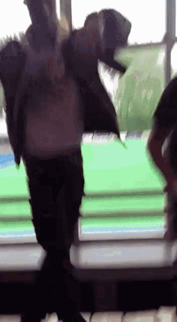 a blurred image of a person dancing in front of a green screen