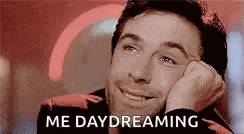 a man is smiling with his hand on his face and the words `` me daydreaming '' written above him .
