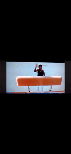 a man is doing a trick on a pommel horse