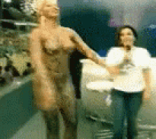 a blurry picture of a woman standing next to a statue of a naked woman