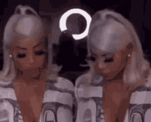 a couple of women standing next to each other in front of a mirror .