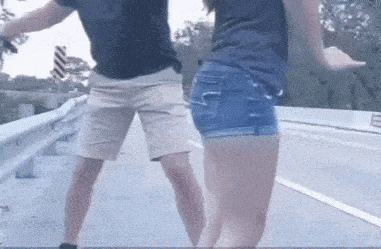 a man and a woman are dancing on a highway .
