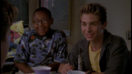 a group of people are sitting at a table talking to each other .