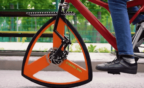 a person is riding a bicycle that has a triangle wheel