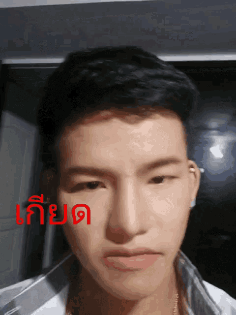 a close up of a man 's face with a foreign language written on the bottom right