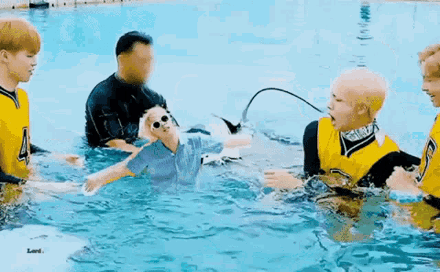 a group of young men are playing in a swimming pool with a scuba diver .