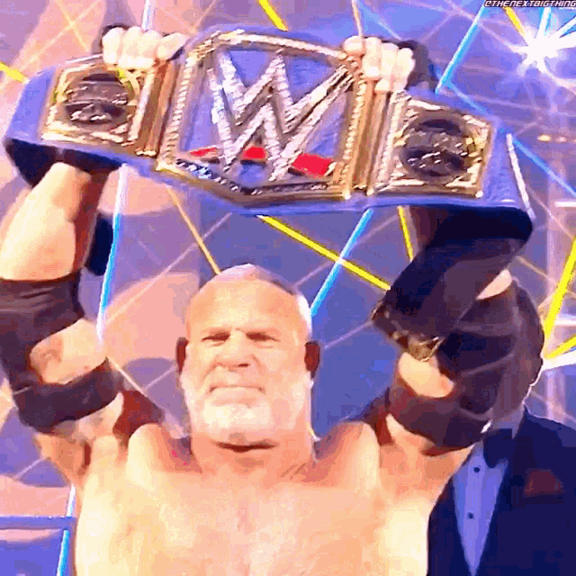 a shirtless wrestler is holding up his wwe championship belt