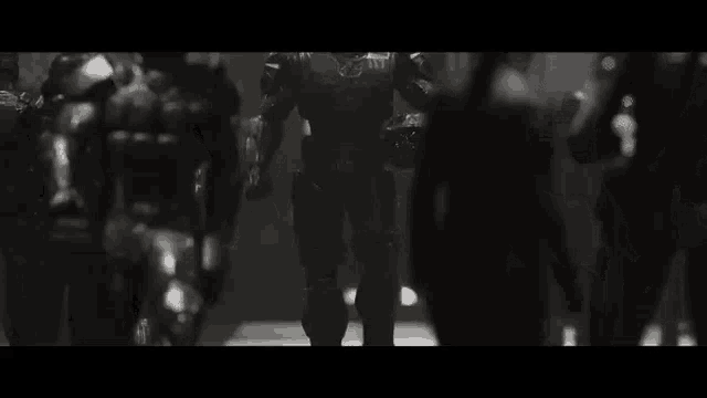 a group of robotic soldiers are walking through a dark room .