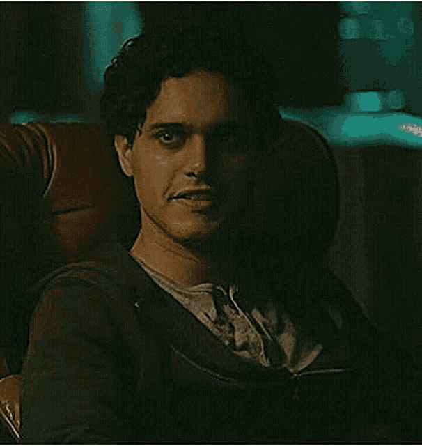 a young man is sitting in a chair in a dark room .