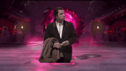 a man in a suit is standing in front of a purple glowing object