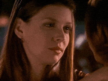 a woman with her eyes closed is holding another woman 's neck