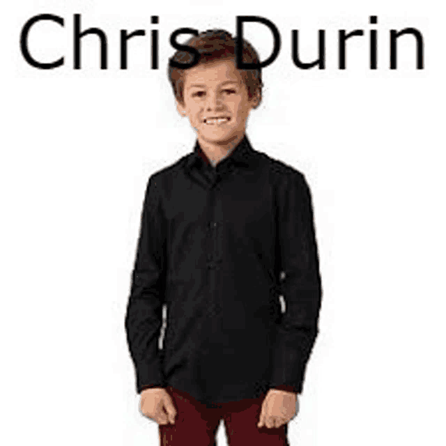a young boy is wearing a black shirt and red pants and smiling .