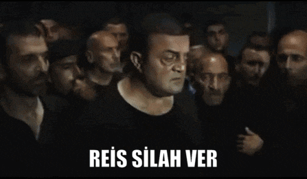 a man is standing in front of a crowd of people with the words reis silah ver written on the bottom .