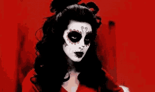 a woman is wearing a day of the dead costume and makeup .