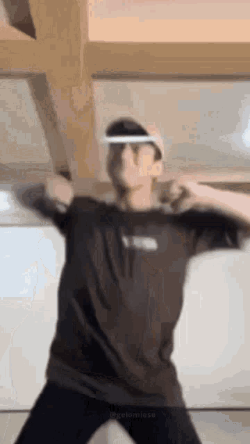 a man in a black shirt and white hat is dancing .