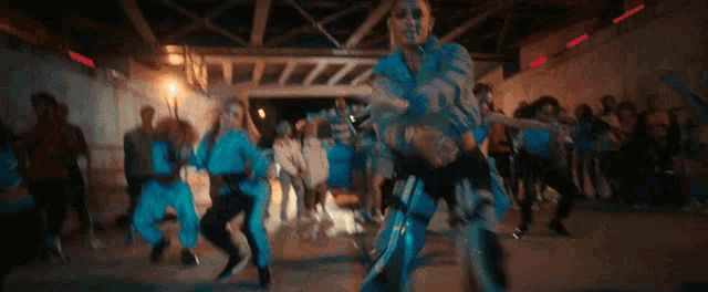 a group of people are dancing in a room with a car in the background .