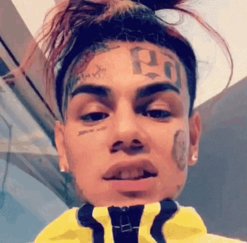 a close up of a man 's face with a tattoo of the number 19 on it