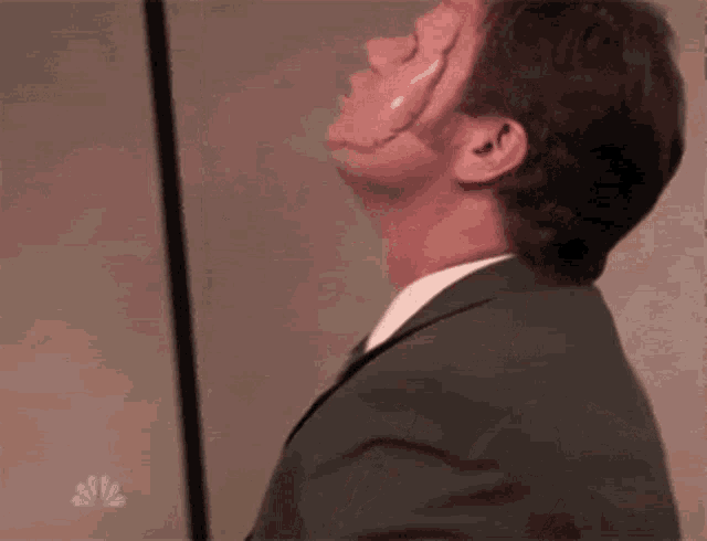 a man in a suit and tie has a huge scar on his face .