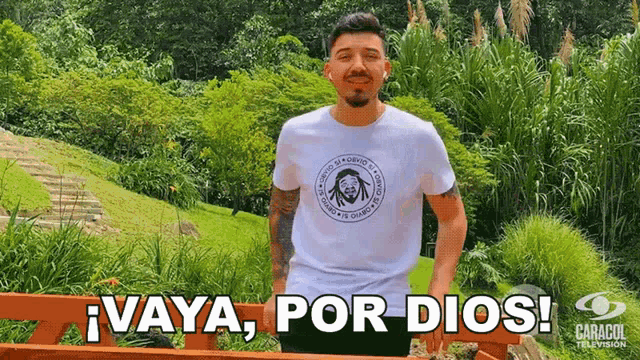 a man wearing a white shirt that says vaya por dios on it