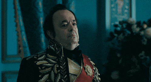 a man in a black and gold uniform with a red sash around his neck