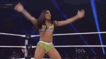 a woman is dancing in a wrestling ring